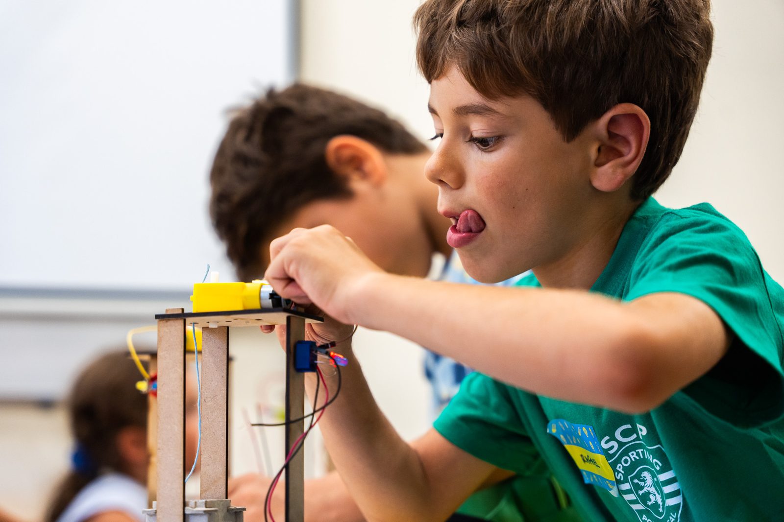 A boy building a wooden crane model
