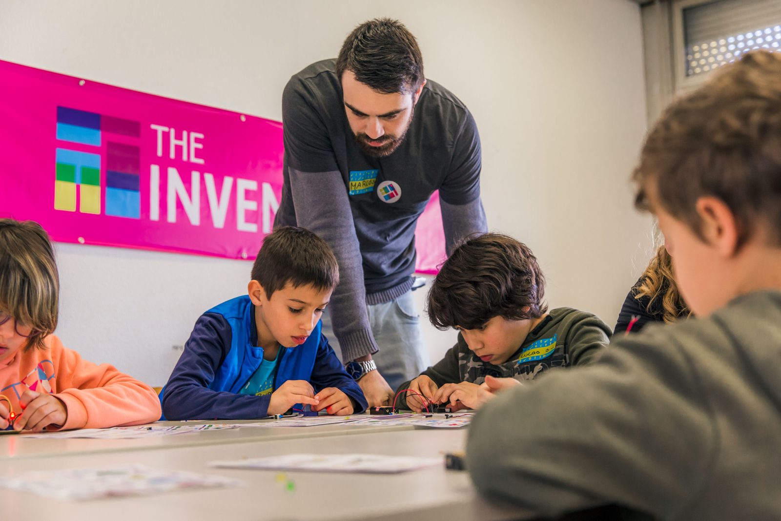 An instructor helps children build circuits